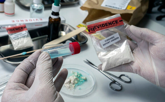 Police scientist holds drug-positive swab, crime lab, concept image