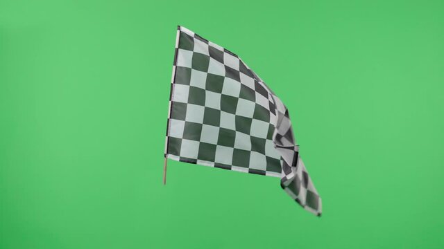 Racing flag silk fabric fluttering against a green screen background. Checkered flag formula one car motor sport. Official finish start race. Racing flag waving. Slow motion.