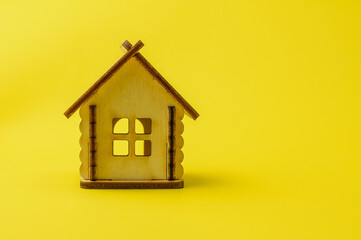Fototapeta na wymiar Miniature wooden house on a colored background. Concept of buying an apartment, house, real estate. Copy space.