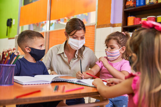 Children and educator in daycare with face mask because of Covid-19
