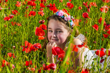 Girl lying on poppy field