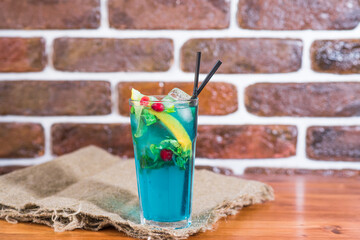 Cold citrus lemonade in a glass on a wooden table