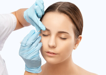 Makeup artist combs  and plucks eyebrows after dyeing in a beauty salon.Professional makeup and...