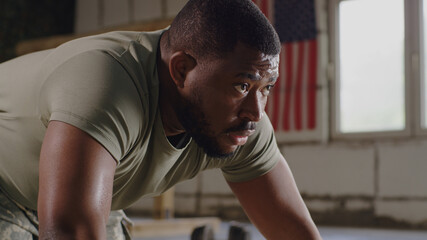 Fototapeta na wymiar Black soldier doing push ups in gym