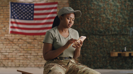 Happy African American military woman making video call in gym