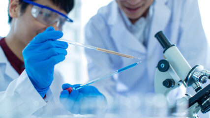 Fototapeta premium Asian chemist working in lab near colleague