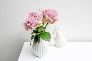 One pale purple rose in a white fluted vase on the table as decoration for the wedding reception