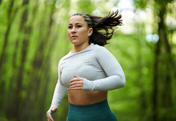 Plus size runner woman in the forest