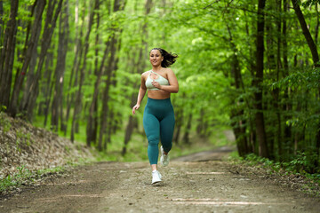 Plus size runner woman in the forest