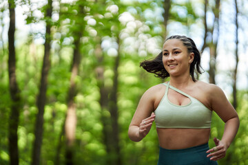 Plus size runner woman in the forest