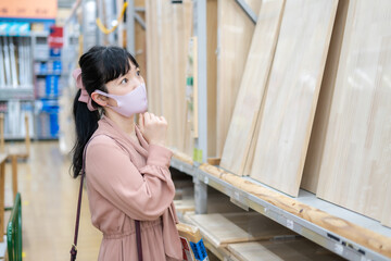 ホームセンターで木材を選ぶ女性