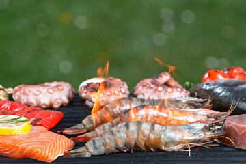Assorted delicious grilled tiger shrimps with various meat and vegetables. Outdoor grill barbecue mix.