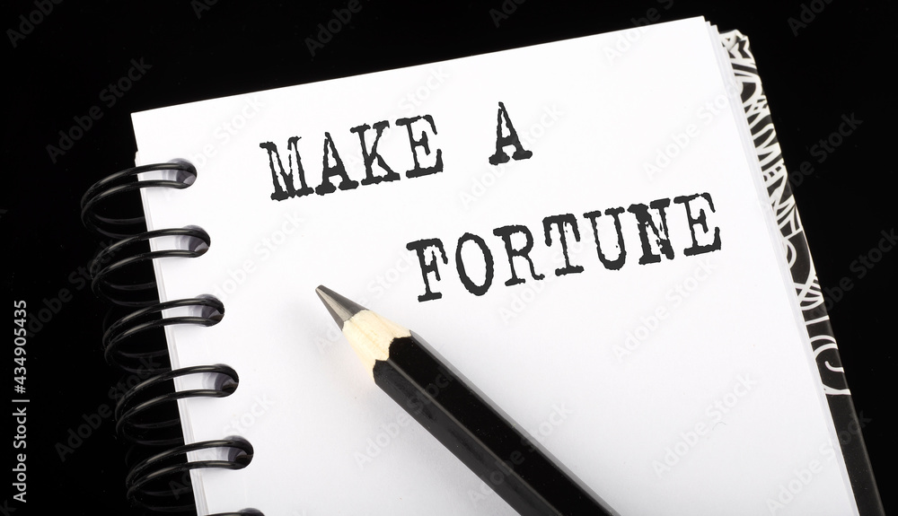 Poster make a fortune written text in small notebook on a black background