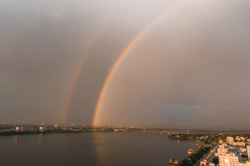 Naklejka na ściany i meble Rainbow is double in the most of photo. Beautiful double rainbow in the city after the rain. Photos taken from the drone