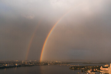 Rainbow is double in the most of photo. Beautiful double rainbow in the city after the rain. Photos taken from the drone