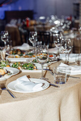 Table setting for a banquet or celebration. Empty wine glasses for spirits, champagne and juice. Set the table. Cloth napkins on a platter. Close-up