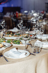 Table setting for a banquet or celebration. Empty wine glasses for spirits, champagne and juice. Set the table. Cloth napkins on a platter. Close-up