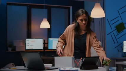 Dismissed unhappy businesswoman packing company stuff putting in white box leaving startup office late at night. Unemployed frustrated worker losing marketing executive manager job