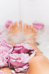 Fototapeta na wymiar Point of view Female feet bathing in rose flowers