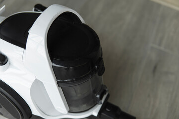 Bagless cyclone vacuum cleaner on a grey tile. Electrical apparatus that by means of suction...