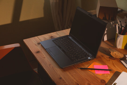 The home office, an example of a space for teleworking from home, in which you can see a black laptop and some colored notes, early in the morning, in Madrid, Spain. Work-life balance.