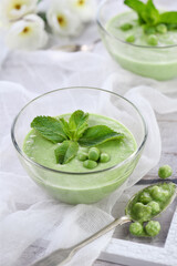 Chilled green pea puree soup with tender milk cream and refreshing mint