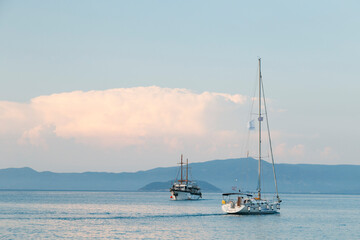 Fototapeta premium Zwei Schiffe auf dem Meer mit Bergen im Hintergrund