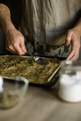 Male hands spreading onion pie filling on a baking sheet