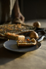 Male hands putting onion pie on a plate