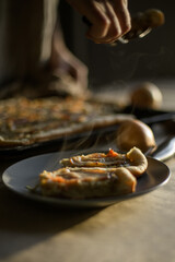 Male hands putting onion pie on a plate