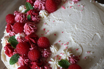 Fototapeta na wymiar Birthday cake with cream and fresh raspberries