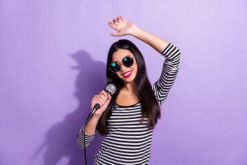 Photo of young beautiful smiling cheerful korean girl dancing enjoying singing karaoke isolated on violet color background