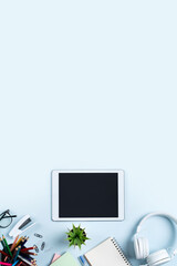Online learning design concept. Top view of student table with tablet, headphone and stationeries.