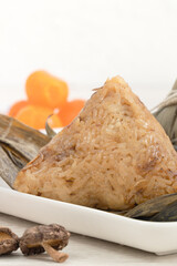 Zongzi. Rice dumpling for Dragon Boat Festival on bright wooden table background with ingredient.