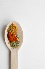 Top view of wooden spoons with brightly assortment colored spices.