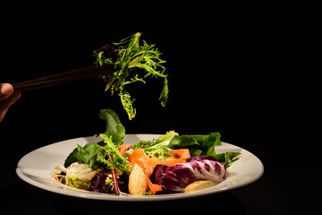 Salad with different ingredients and black background