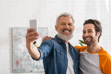 Mature man taking selfie with smiling son