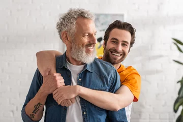 Foto op Plexiglas Smiling man hugging mature dad at home © LIGHTFIELD STUDIOS