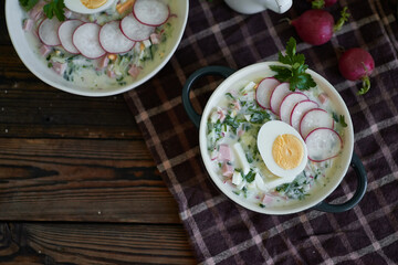 Traditional Russian cold okroshka soup served in a plate with herbs Kefir vegetable soup