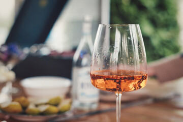 A glass of orange lemonade against the background of a blurred table on veranda