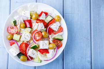 Greek salad. Traditional Greek dish. Healthy vegetarian food. Fresh vegetables and feta cheese in a white plate. Close-up.