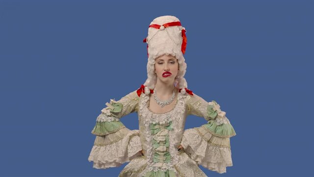 Portrait of courtier lady in white vintage lace dress and wig, enjoying chewing gum. Young woman posing in studio with blue screen background. Close up. Slow motion ready 59.94fps.
