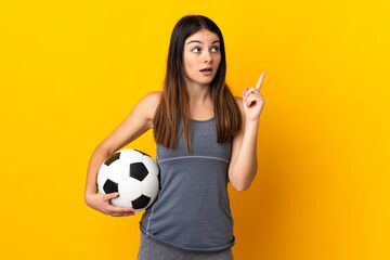 Young football player woman isolated on yellow background thinking an idea pointing the finger up