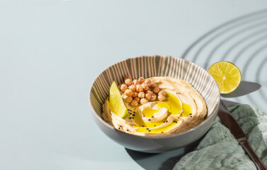 Chickpea hummus with olive oil and lime on a ceramic plate. Homemade classic hummus. Chickpea dishes, vegetarian dish.