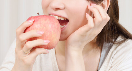 リンゴにかぶりつく若い女性