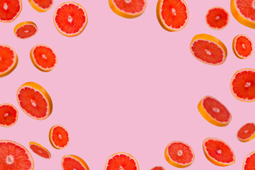 Frame of sliced fresh grapefruit isolated on light pink background.
