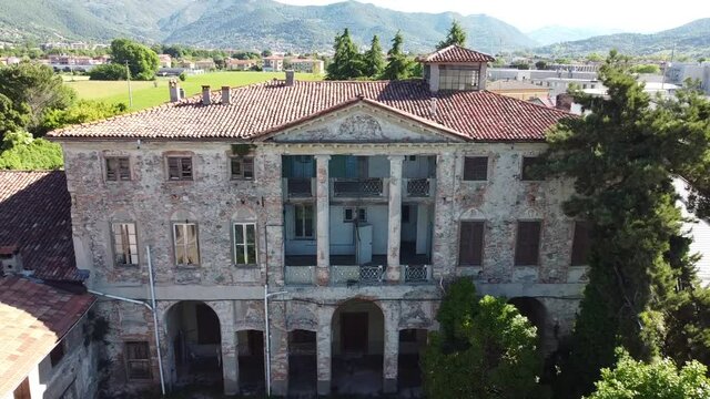 Aerial shot of an abandoned historic villa, video moving away from a ruined Italian building