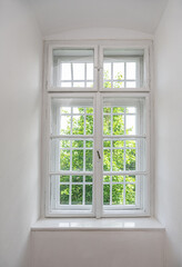 An old white window at the entrance of an old house.