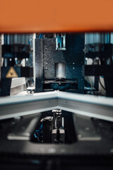 Close up shot of modern CNC machine working on welding and cleaning PVC and aluminum doors and windows. Production factory details.