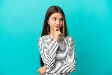 Little girl over isolated blue background having doubts and thinking